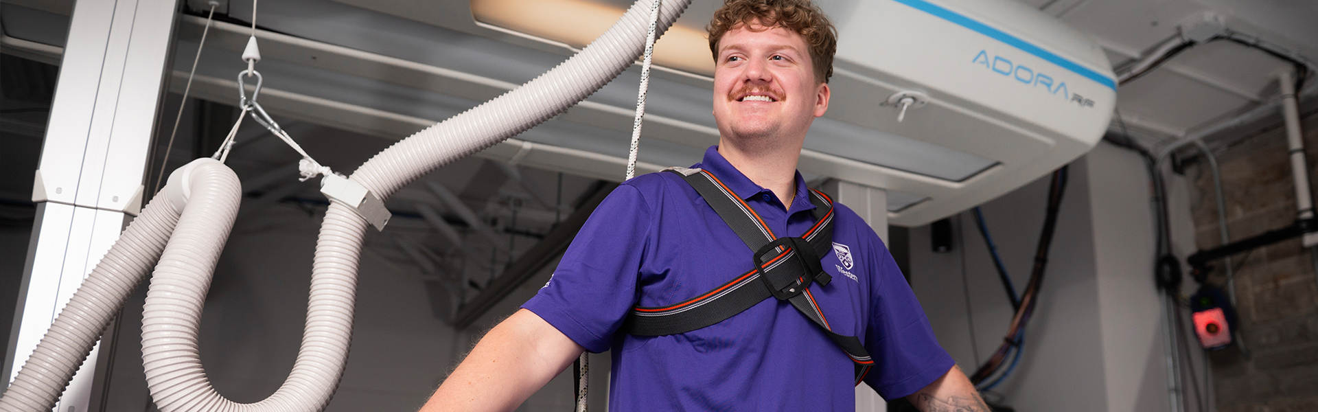 A student standing at some research equipment.