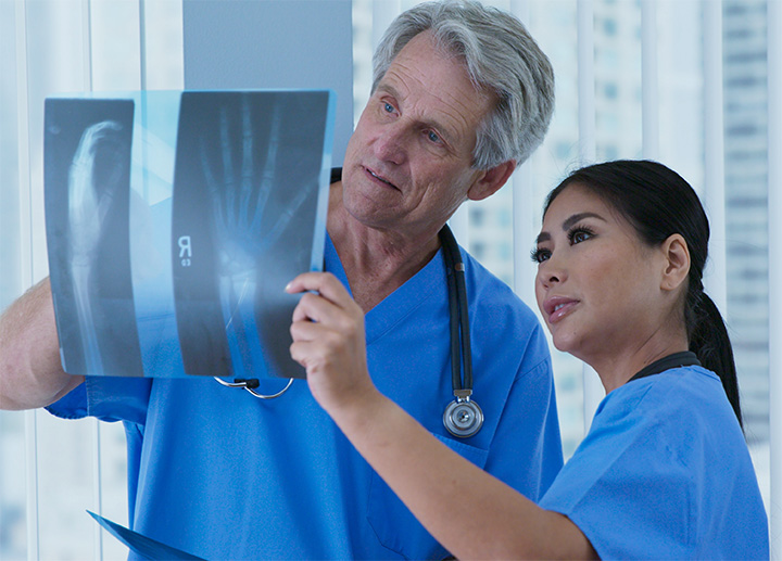 Medical professionals reviewing a hand X-ray.